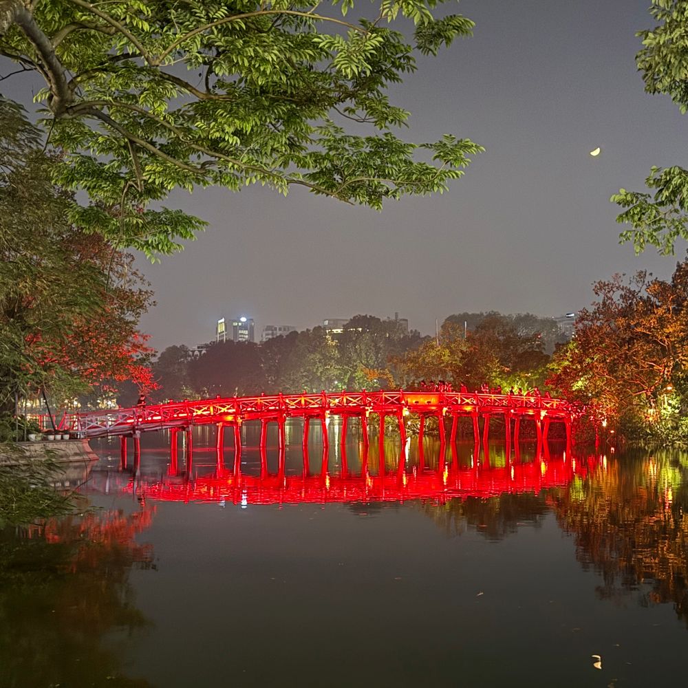 The red Huc Bridge lit up at night, leading to Ngoc Son Temple in Hanoi