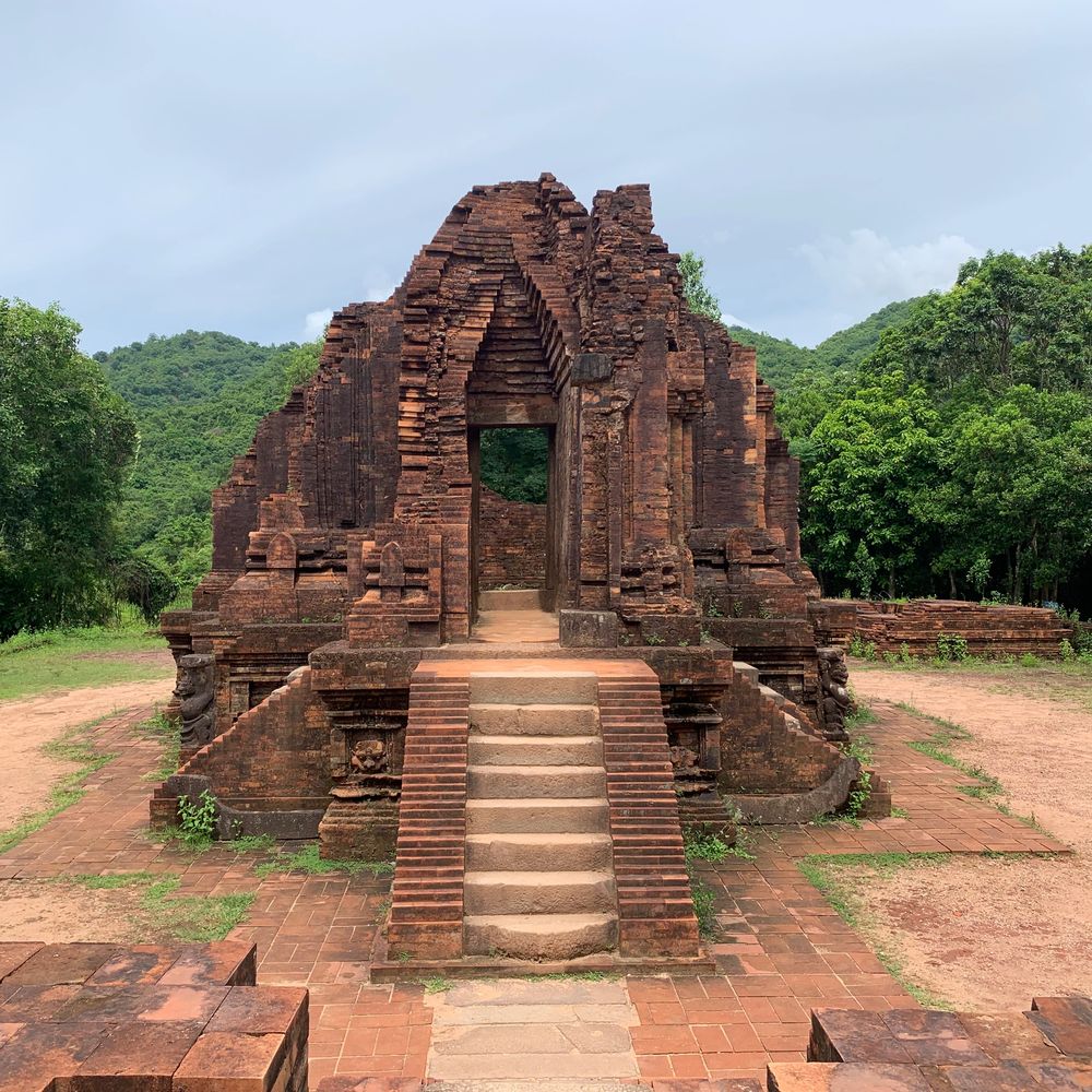 Ancient brick temple ruins at My Son sanctuary, set against forested hills