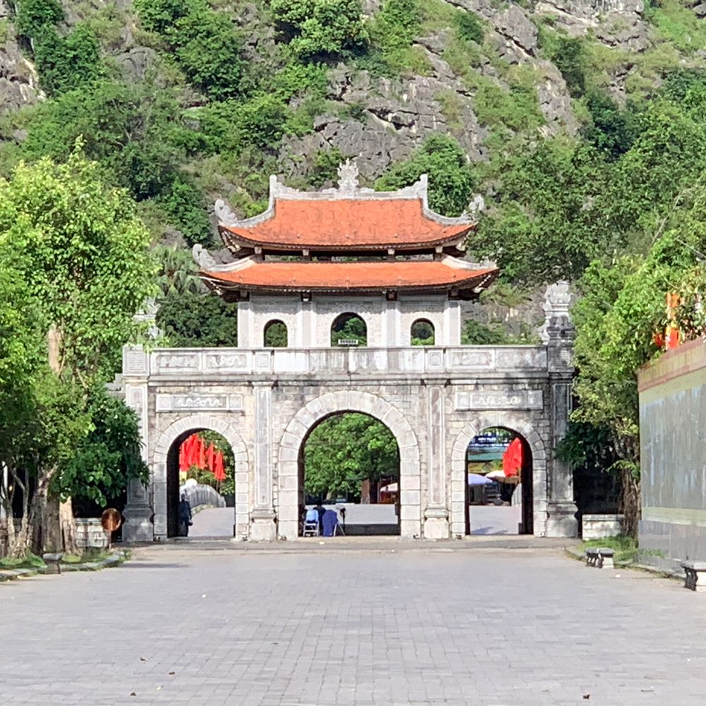 Stone entrance gate to the historic Hoa Lu citadel beneath limestone cliffs