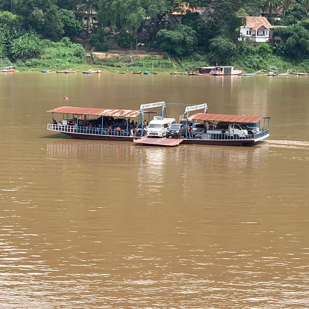 River ferry carrying a vehicle across the muddy Mekong River