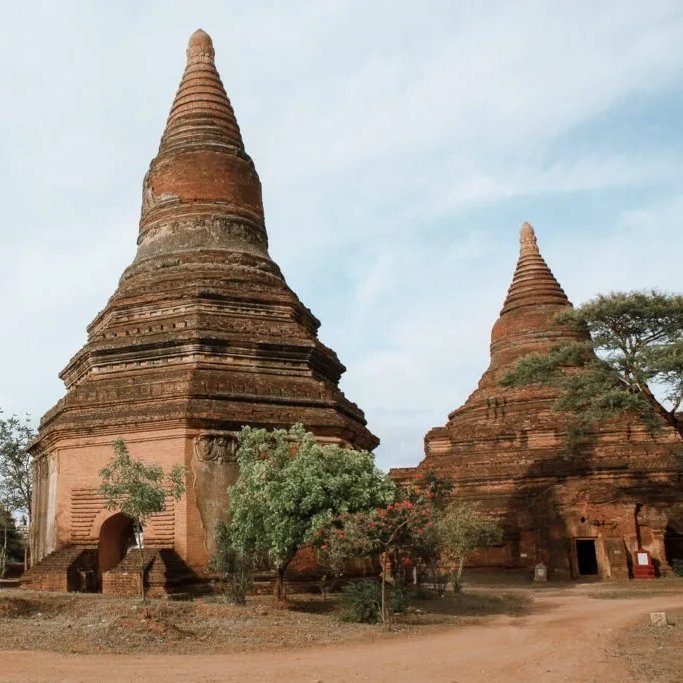 Ancient brick temples standing among trees on the Bagan plain
