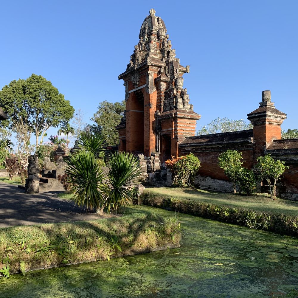 Brick-and-stone Balinese temple with manicured tropical gardens