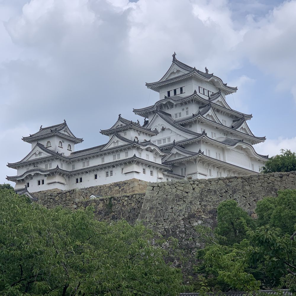White-walled Himeji Castle perched above the trees
